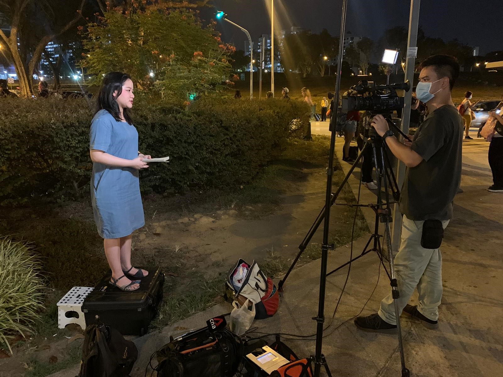 Gwyneth preparing to give a live report at Woodlands Checkpoint. At the time, masks were not compulsory yet. 